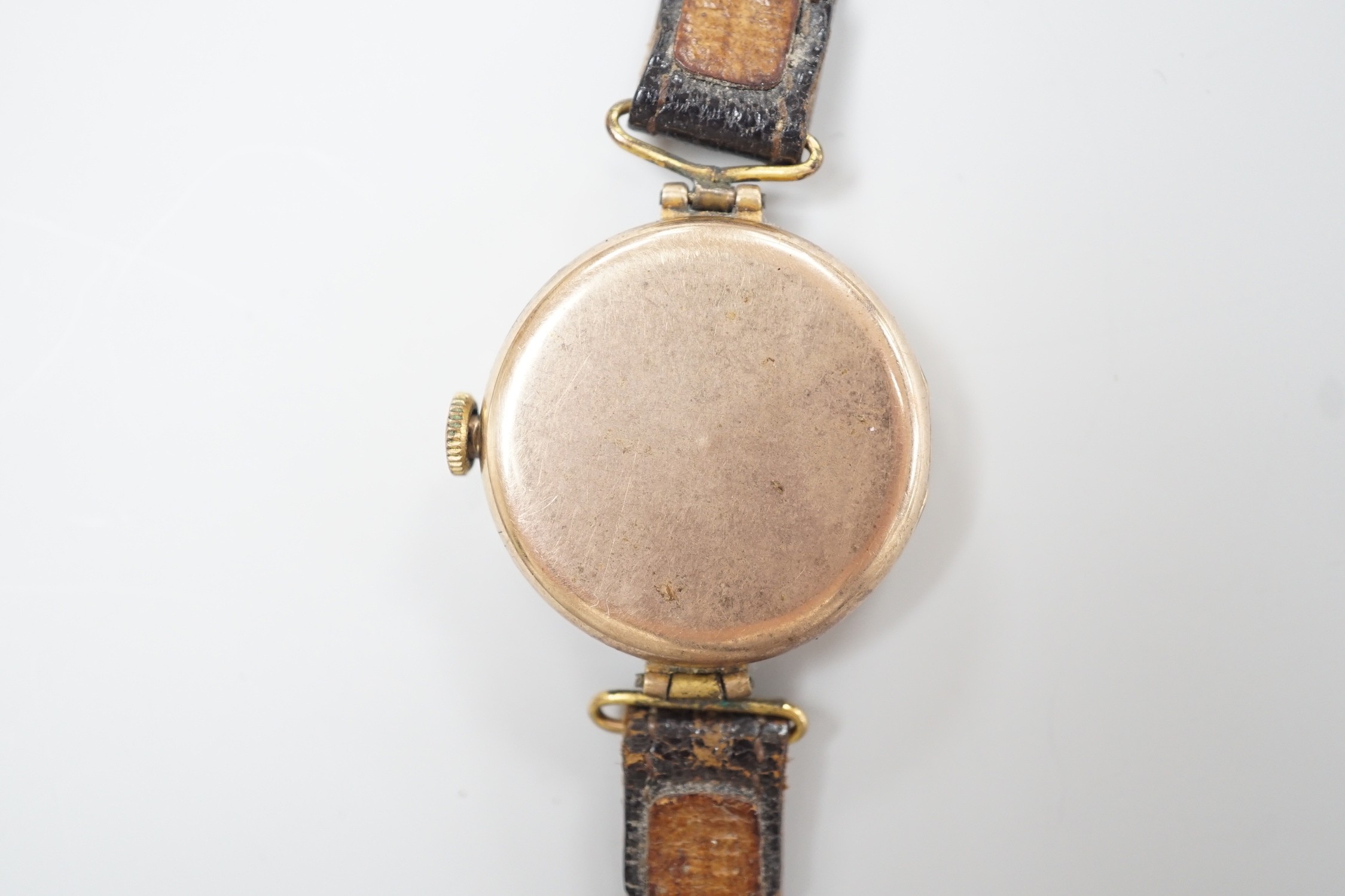 A lady's early 20th century 9ct gold wrist watch, with Arabic dial and RolWatchCo (Wilsdorf & Davis) case, movement unsigned, on associated leather strap, case diameter 26mm, gross weight 17.5 grams.